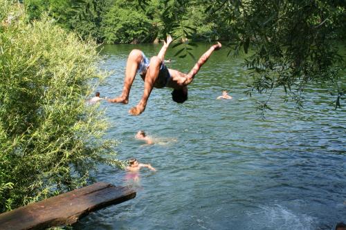 a man jumping into a body of water at RIVER KOLPA APARTMENT, Griblje ob reki Kolpi in Gradac