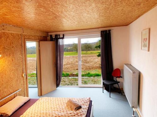 een slaapkamer met een bed en een groot raam bij My-Skypalace Billigheim in Billigheim