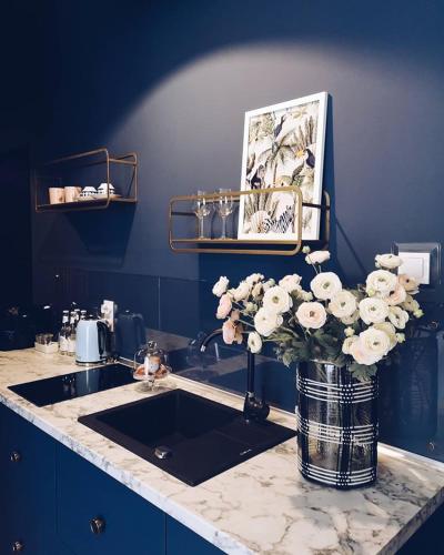 a kitchen counter with a sink and a vase of flowers at Rost Apartments in Bielsko-Biała