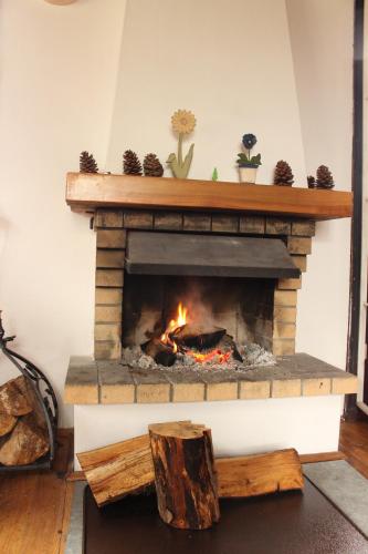 a brick fireplace with a fire in it at Domek Letniskowy nad Jeziorem Tumiany in Bartołty Wielkie
