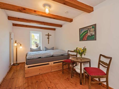 Hof Lewin في Dargen: غرفة نوم بسرير وطاولة وكراسي