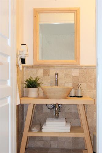 a bathroom with a sink and a mirror and towels at Villamer Alaçatı in Alaçatı