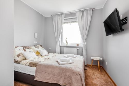 a small bedroom with a bed and a window at Willa Parys in Władysławowo