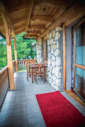 a porch of a house with a table and a red rug at Rezydencja Sąsiadów Zakopanego in Zakopane