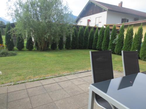 a garden with a fence and a table and chairs at Alpenotel Rosenhof Ruhpolding, Wellness, Chiemgau Karte, Travelingo Bonus Programm in Ruhpolding