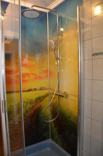 a bathroom with a shower with a painting of a field at Pension Restaurant Rosenberg in Jennersdorf