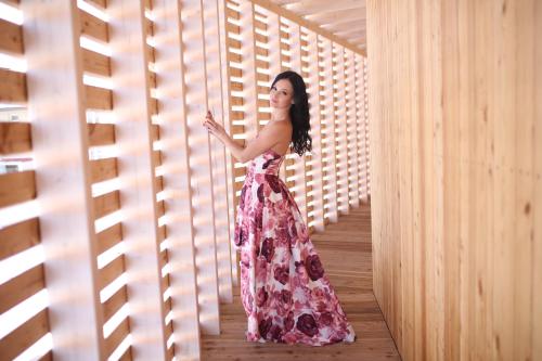 a woman in a floral dress standing in a hallway at tvrz KRASSA in Osečná