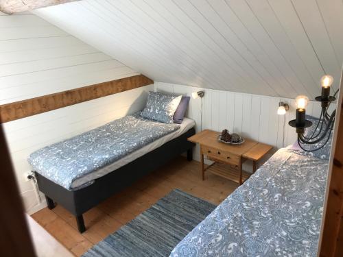 a attic room with two beds and a table at Seaside Cottage House nr 1, Saltvik Hudiksvall in Hudiksvall