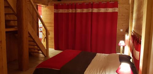 a bedroom with a red curtain and a bed at Le Jura en toutes saisons Piscine, SPA, location VTT, balades 2cv, climatisation in Bonlieu