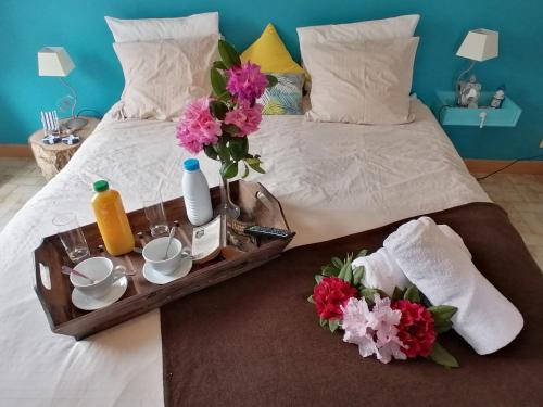 - un lit avec un plateau de nourriture et de fleurs dans l'établissement Proche Le Pouldu, cadre verdoyant avec parking, à Clohars-Carnoët