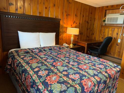 a bedroom with a bed and a desk and a chair at Budget Inn in Belle Vernon