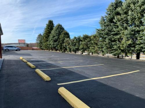 a parking lot with some yellow poles in it at Budget Inn in Belle Vernon