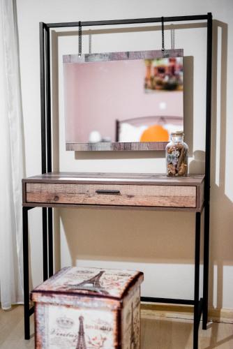 a console table with a mirror and a box at Christi Iuxury Apartment in Preveza