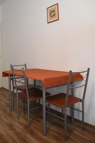 a dining room table and two chairs and a picture at Tihany Község Önkormányzat - Ifjúsági Szállás in Tihany