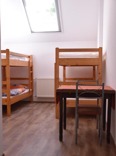 a room with two bunk beds and a table and chair at Tihany Község Önkormányzat - Ifjúsági Szállás in Tihany