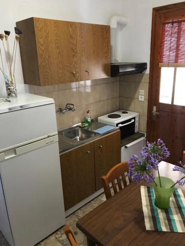 a kitchen with a white refrigerator and a table at ΠΕΝΥ ΚΑΝΤΙΑ 1ος Ν 5 in Kandia