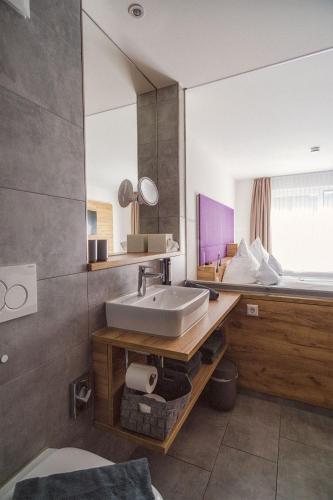 a bathroom with a sink and a large mirror at Hotel Restaurant Kochschule Rössle in Elzach