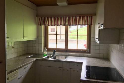 a kitchen with a sink and a window at Ferienwohnung Uf Z`Enisch in Klosters