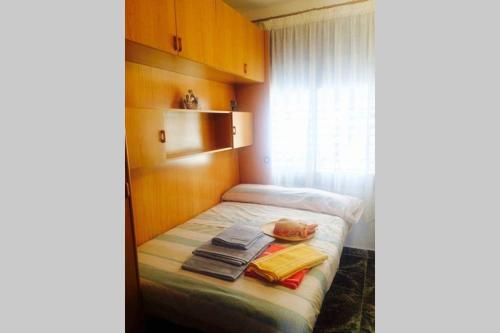 una piccola camera da letto con un letto con asciugamani sopra di Apartamento entre la playa y la montaña a Calafell