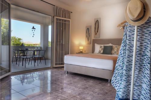 a bedroom with a bed and a patio with a table at Olive House in Malia