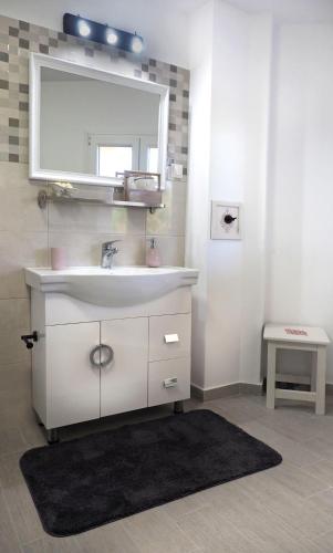 a bathroom with a sink and a mirror at Olive House in Malia