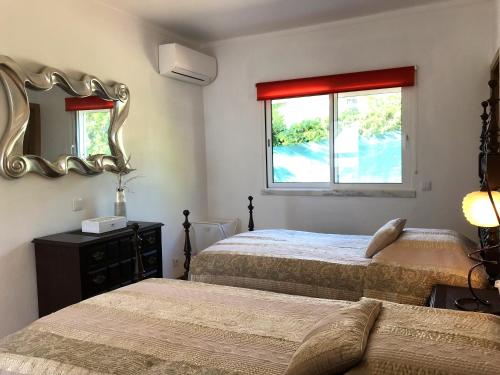 a bedroom with two beds and a mirror at Villa Sunkiss Algarve Carvoeiro in Carvoeiro