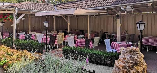 a group of tables and chairs under an umbrella at Piccolo Panzió Vendéglő Vinoteca in Zalaegerszeg