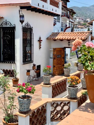 a courtyard with potted plants and a church at Hotel Santa Paula in Taxco de Alarcón