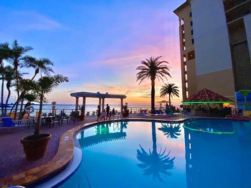 - une piscine sur la plage avec un coucher de soleil en arrière-plan dans l'établissement Holiday Inn & Suites Clearwater Beach, an IHG Hotel, à Clearwater Beach