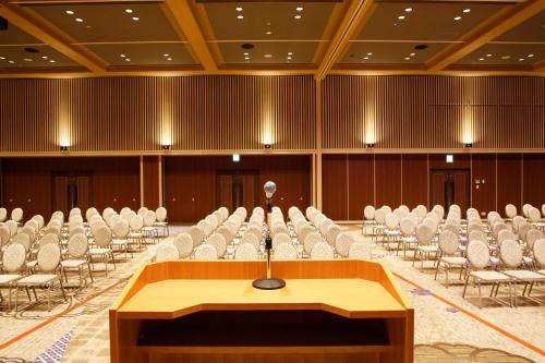 a podium in the middle of a room with chairs at The Shiroyama Terrace Tsuyama Villa in Tuyama