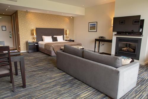 a hotel room with a bed and a couch at Braemar Lodge And Spa in Hanmer Springs