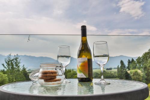 a bottle of wine and two glasses on a table at Braemar Lodge And Spa in Hanmer Springs