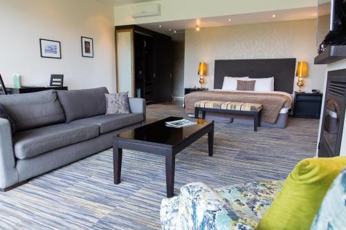 Braemar Lodge And Spa في هانمر سبرينغز: غرفة معيشة مع أريكة وسرير