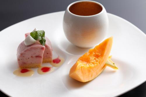 a white plate with three desserts and a cup of coffee at The Shiroyama Terrace Tsuyama Villa in Tuyama