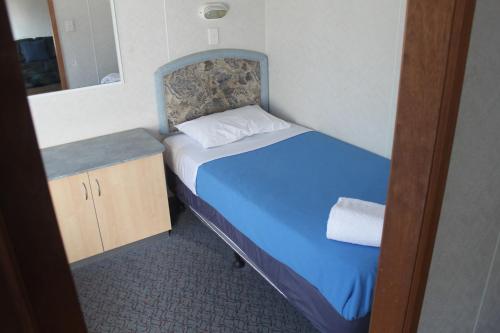 a small bedroom with a bed and a mirror at Capital Country Holiday Park in Canberra