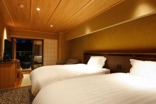 a hotel room with two beds and a window at The Shiroyama Terrace Tsuyama Villa in Tuyama