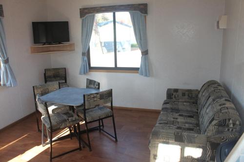 a living room with a table and a couch at Capital Country Holiday Park in Canberra