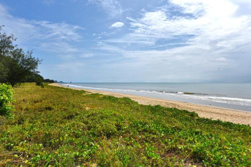 a sandy beach with the ocean in the background at Golden Sands Beachfront Resort in Yorkeys Knob