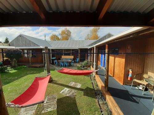 a house with two hammocks in a yard at Tongariro River Retreat in Turangi