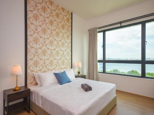 a bedroom with a bed and a large window at Marina View Resort by Nest Home [Bathtub & Seaview!] in Johor Bahru