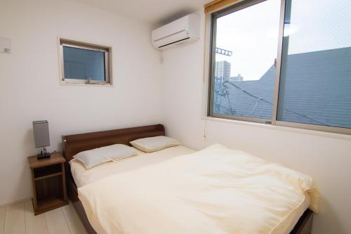 a small bedroom with a bed and a window at Convertel Honhaneda by Tranova in Tokyo