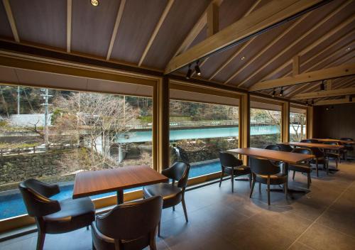 a restaurant with tables and chairs and large windows at Asan Kotonami in Manno
