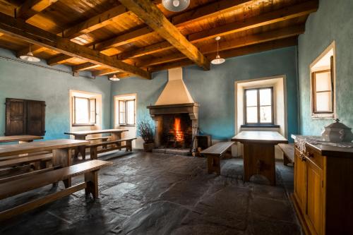 a large room with benches and a fireplace at Ostello Podesteria di Gombola - arte e territorio in Polinago