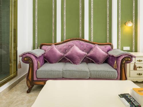 a purple couch sitting in a living room at April Fair Duplex Apartment Guangzhou South Railway Station Ao Yuan Yue Shi Dai Branch in Guangzhou