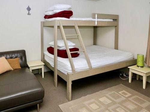 - une chambre avec un lit superposé avec des oreillers et un canapé dans l'établissement Harakeke House Downstairs - Ohakune Unit, à Ohakune