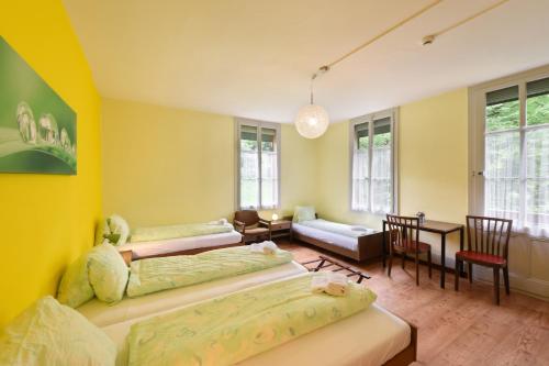 a bedroom with two beds and a table and chairs at Budget Waldhotel Unspunnen in Interlaken