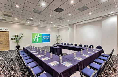 a conference room with tables and chairs and a screen at Holiday Inn Express Villahermosa by IHG in Villahermosa