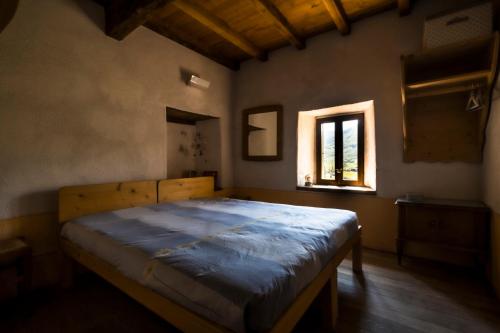 a bedroom with a bed in a room with a window at Ostello Podesteria di Gombola - arte e territorio in Polinago