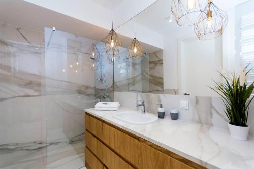 ein Bad mit einem Waschbecken und einem Spiegel in der Unterkunft Yellow Rentyear Apartments in Danzig