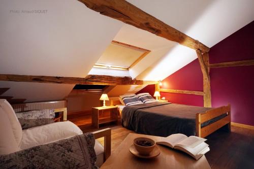 a bedroom with a bed and a chair and a table at ferme st martin in Manhay